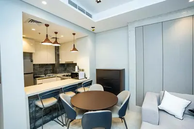 a kitchen and dining room with a table and chairs at High-Rise Comfort 2BR in Nobles Tower in Dubai in Dubai