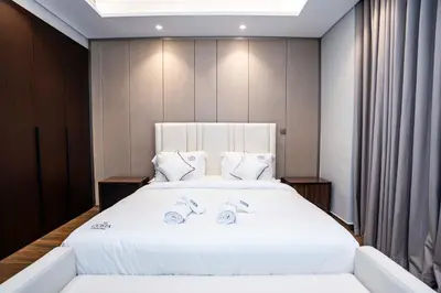 a bedroom with a large white bed with two slippers at High-Rise Comfort 2BR in Nobles Tower in Dubai in Dubai