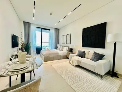 a living room with a couch and a table at Luxe Studio Retreat Jacuzzi Parking, Pool & Gym in Dubai