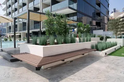 a bench in front of a building with plants at Luxe Studio Retreat Jacuzzi Parking, Pool & Gym in Dubai