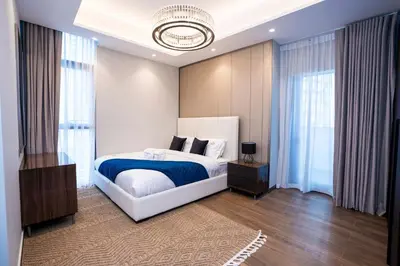 a bedroom with a large bed with a blue blanket at Elegant 2BR Apt Nobles Tower with Pool and Gym in Dubai