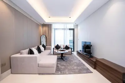 a living room with a couch and a tv at Elegant 2BR Apt Nobles Tower with Pool and Gym in Dubai