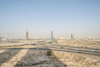 a highway in the middle of a desert with buildings at Stylish 1BR Apartment in Binghatti Luna JVC Dubai in Dubai