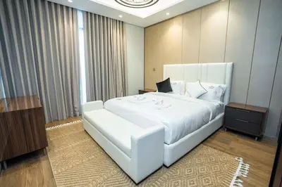 a bedroom with a large white bed and a window at Modern 2BR Apartment Nobles Tower Dubai Views in Dubai