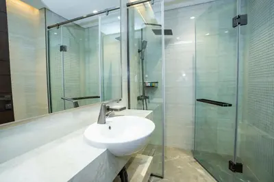 a bathroom with a sink and a glass shower at Modern 2BR Apartment Nobles Tower Dubai Views in Dubai