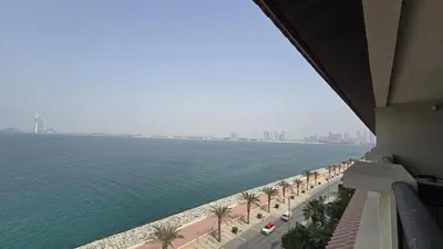 a view of the water from a building with palm trees at Stunning 1BR at Anantara Sea Views Palm Jumeirah in Dubai