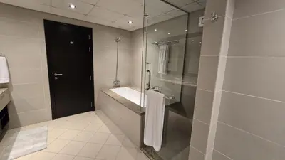 a bathroom with a sink and a glass shower at Stunning 1BR at Anantara Sea Views Palm Jumeirah in Dubai