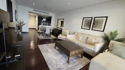 a living room with couches and a dining room at Stunning 1BR at Anantara Sea Views Palm Jumeirah in Dubai