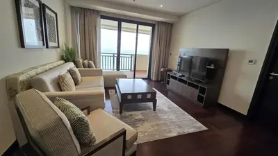 a living room with a couch and a television at Stunning 1BR at Anantara Sea Views Palm Jumeirah in Dubai