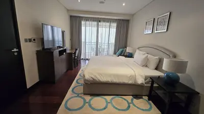a bedroom with a bed and a flat screen tv at Stunning 1BR at Anantara Sea Views Palm Jumeirah in Dubai