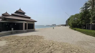 an empty road next to the ocean with a building at Stunning 1BR at Anantara Sea Views Palm Jumeirah in Dubai