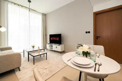 a living room with a white table and a tv at Luxury 1BR Apt Binghatti Amber Prime Location in Dubai