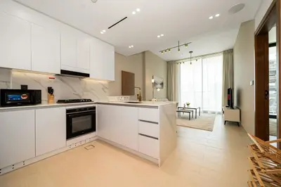 a kitchen with white cabinets and a large window at Luxury 1BR Apt Binghatti Amber Prime Location in Dubai