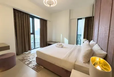 a bedroom with a large bed and large windows at Elegant Style Brand new 2BDR in Heart of Downtown in Dubai