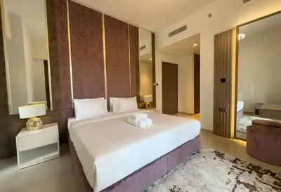 a bedroom with a large bed with a stuffed animal on it at Elegant Style Brand new 2BDR in Heart of Downtown in Dubai