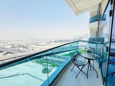 a balcony with a table and chairs on a building at Luxury 1BR The Bay Scenic Canal Creek Outlook in Dubai