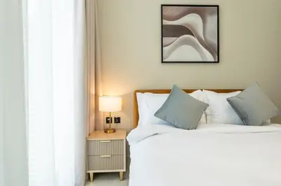 a bedroom with two beds and a table with a lamp at Comfortable 1-Bedroom Getaway Binghatti House in Dubai