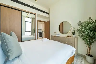 a bedroom with a large white bed and a mirror at Comfortable 1-Bedroom Getaway Binghatti House in Dubai