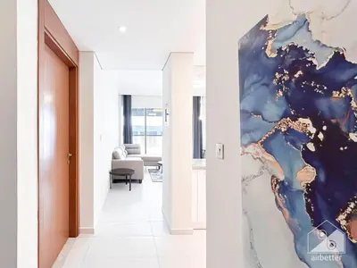 a living room with a painting on the wall at Stylish 1-Bedroom Retreat with Balcony Views in Dubai