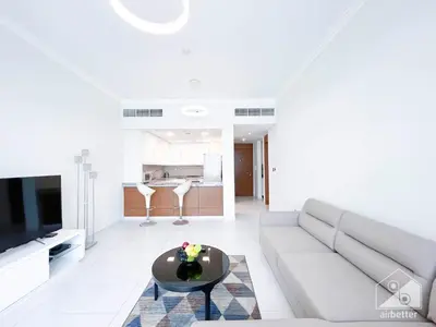 a living room with a couch and a table at Stylish 1-Bedroom Retreat with Balcony Views in Dubai