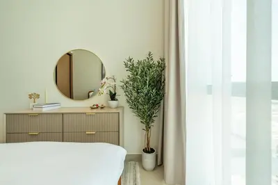 a bedroom with a mirror and a dresser with a plant at Skyline Views from Binghatti House in Dubai