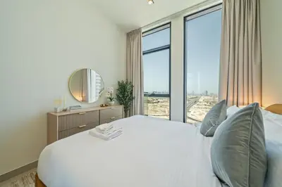 a bedroom with a white bed and a large window at Skyline Views from Binghatti House in Dubai