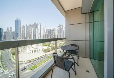 a balcony with a table and chairs and a city at Stylish Studio Steps from Burj Khalifa Fountains in Dubai