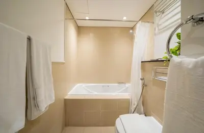 a bathroom with a tub and a toilet and a sink at Stylish Studio Steps from Burj Khalifa Fountains in Dubai