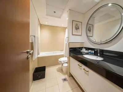 a bathroom with a sink and a mirror and a toilet at Stylish Studio Steps from Burj Khalifa Fountains in Dubai