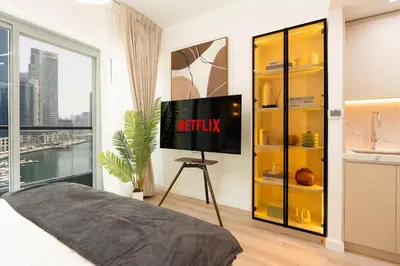 a bedroom with a tv with the netflix sign on the wall at Keyrock - Dubai Marina Apartment with Stunning Sea View, Pool, Gym & Free Parking in Dubai