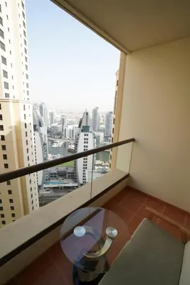 a balcony with a table and a view of a city at Spacious 2 Bedroom in JBR with beach access in Dubai