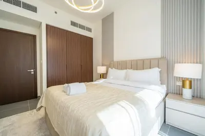 a bedroom with a large bed and two lamps at Modern 1 BR in Creek Edge Ideal Family Living in Dubai
