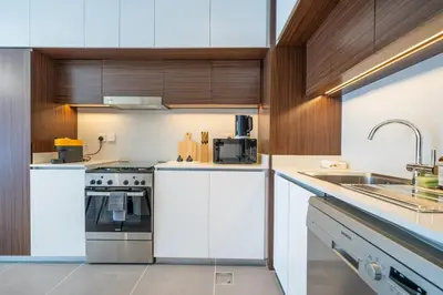 a kitchen with white cabinets and a sink at Modern 1 BR in Creek Edge Ideal Family Living in Dubai