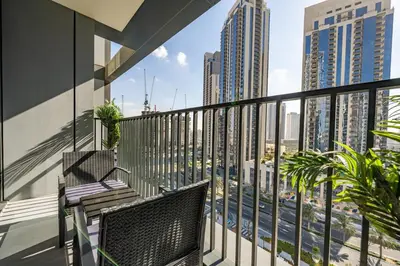a balcony with two chairs and a view of the city at Modern 1 BR in Creek Edge Ideal Family Living in Dubai