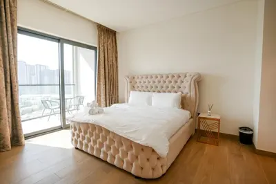 a bedroom with a large bed with a large window at SOBHA Hartland Grande 1 BHK in Dubai