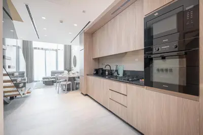 a kitchen with a large black appliance in a room at Chic Duplex 1BHK by CzechIn Luxe Stay with Pool Gym in Dubai