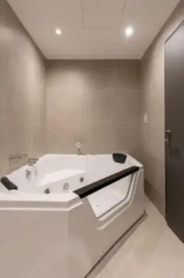 a white bath tub in a bathroom at Nasma Luxury Stays - Jacuzzi Dreams 1 BR in Jumeirah in Dubai