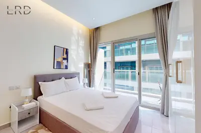a bedroom with a bed and a large window at Elegant and Modern 1BR Apartment in Dubai