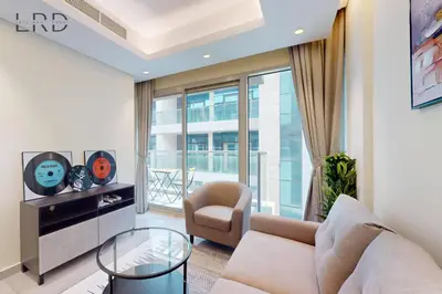 a living room with a couch and a table at Elegant and Modern 1BR Apartment in Dubai
