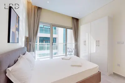a bedroom with a bed and a large window at Elegant and Modern 1BR Apartment in Dubai