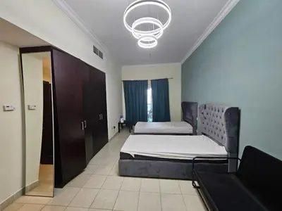 a bedroom with two beds and a mirror at Budget Spacious Room Heart of marina in Dubai