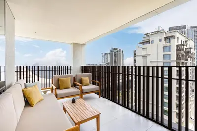 a balcony with a couch and chairs and a view of a city at Lux Creek Home with Burj View steps from the Lagoon in Dubai