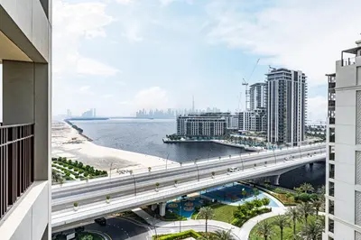 a bridge over the water in a city with buildings at Lux Creek Home with Burj View steps from the Lagoon in Dubai