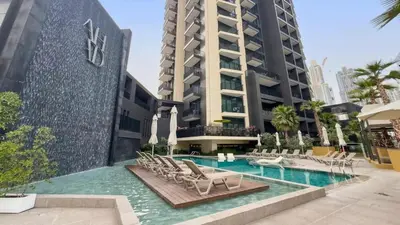 a swimming pool with chairs and a building at TRPS - Ahad Residences, Business Bay - Full Burj Khalifa View - Modern Furnished Studio in Dubai