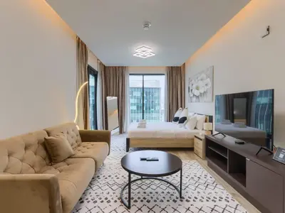 a living room with a couch and a television at TRPS - Ahad Residences, Business Bay - Full Burj Khalifa View - Modern Furnished Studio in Dubai