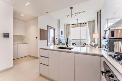 a kitchen with white cabinets and a counter top at Sky Level 1BR with Lake View and City Glimpse, Close Proximity to Community Park, Binghatti Onyx, Jumeirah Village Circle by Deluxe Holiday Homes in Dubai