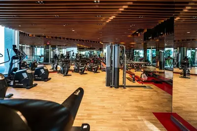 a gym with a bunch of treadmills and machines at Stylish Studio Bayz Danube Burj Khalifa View Pool in Dubai
