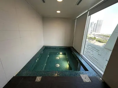 a swimming pool in a building with a large window at Stylish Studio Bayz Danube Burj Khalifa View Pool in Dubai