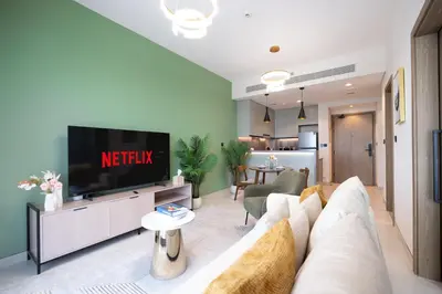 a living room with a couch and a tv at Keyrock Golf Gate - Damac Hills Apartment with Pool, Gym & Free Parking in Dubai