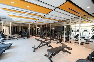 a gym with a lot of treadmills and machines at Keyrock Golf Gate - Damac Hills Apartment with Pool, Gym & Free Parking in Dubai